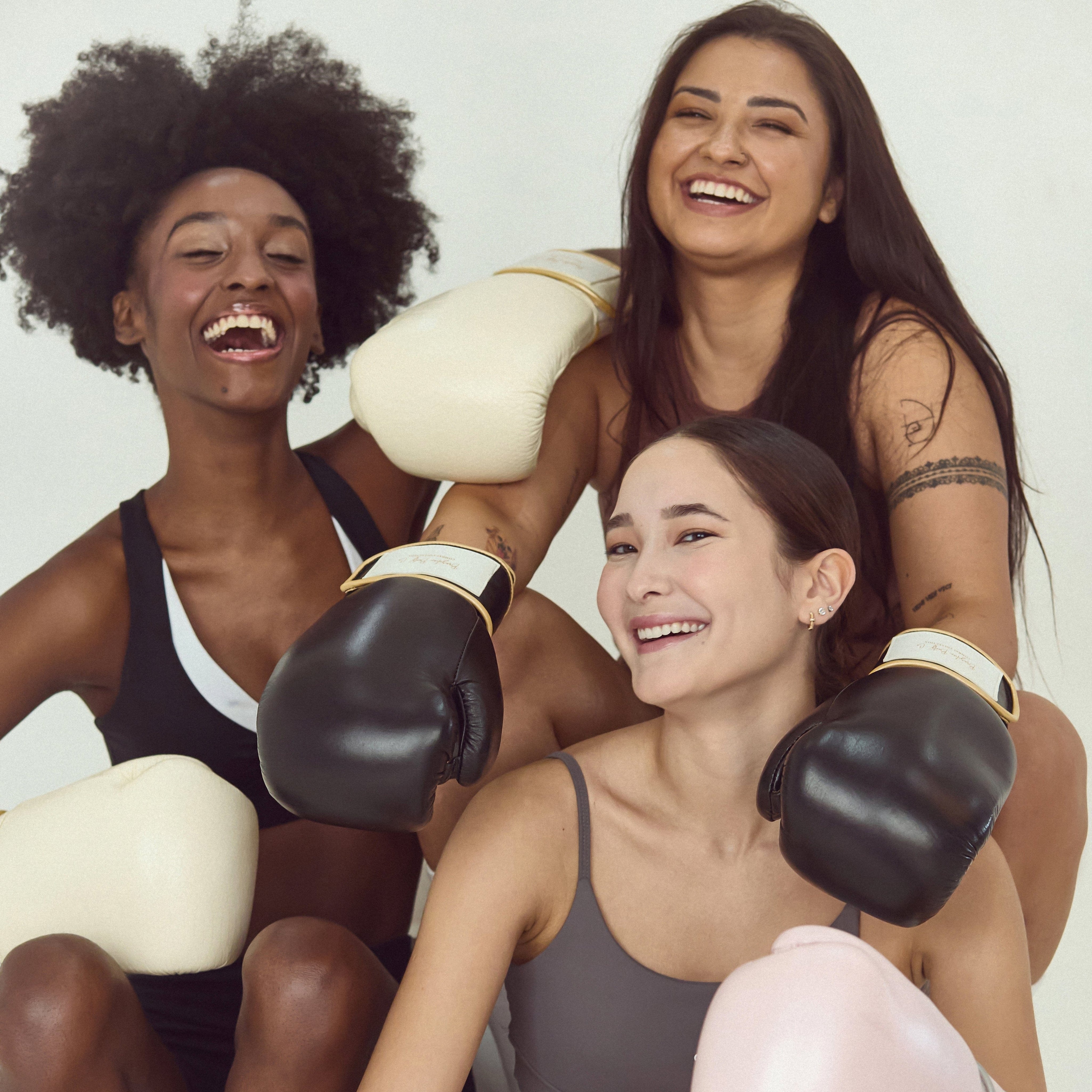 Fitness model posing in seamless activewear set with boxing gloves
