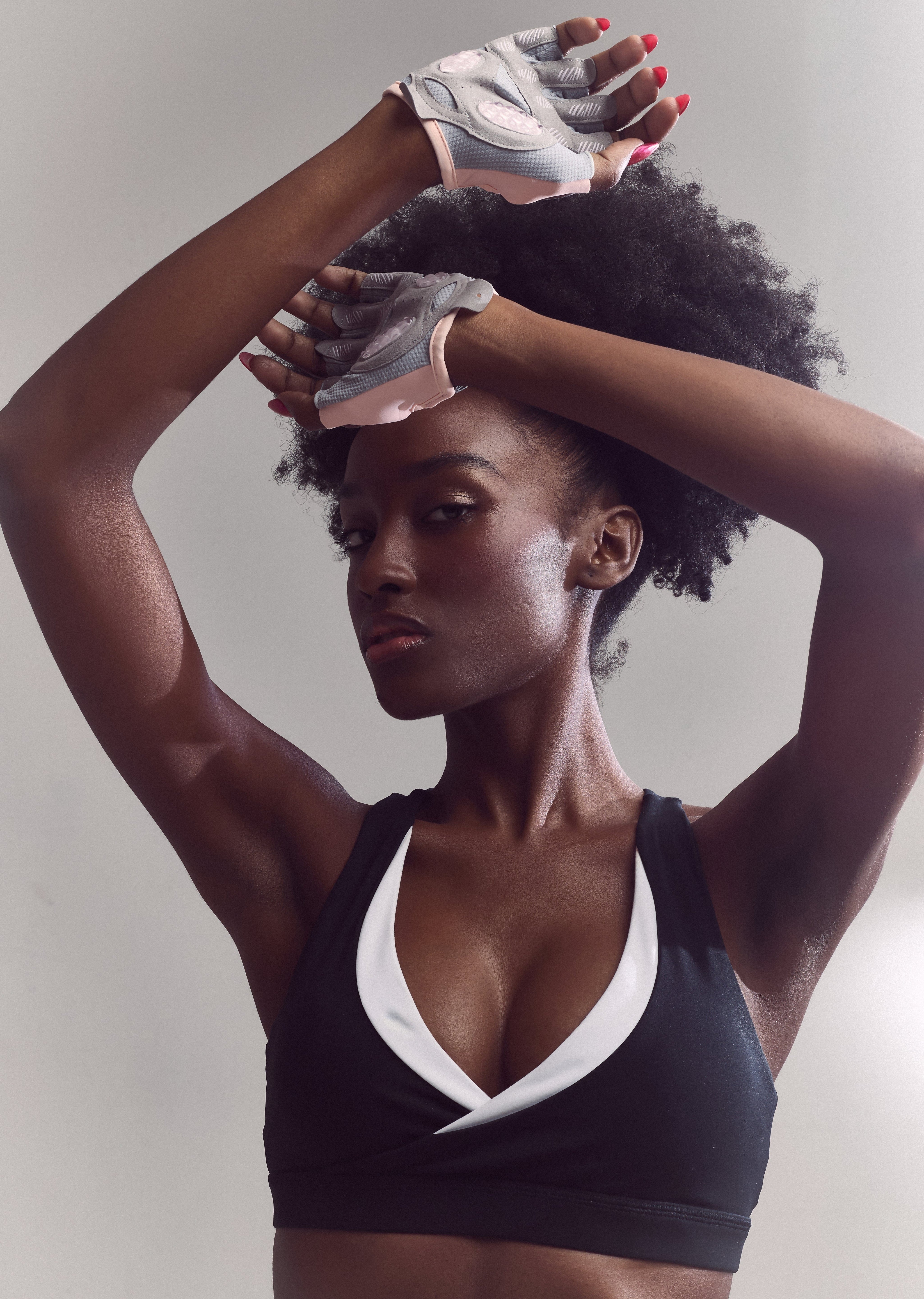 Woman in sports bra wearing training gloves