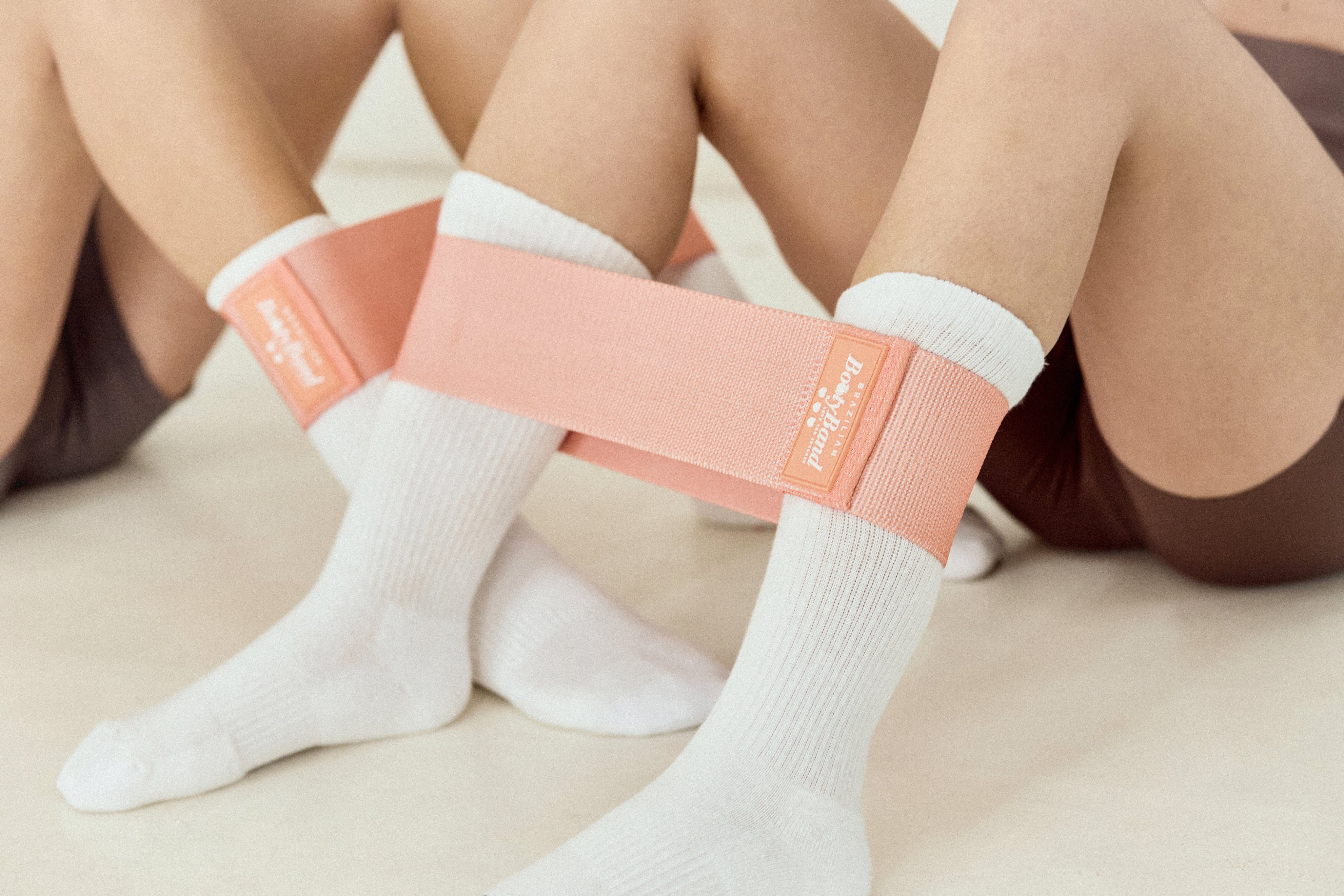 Women using peach resistance band on legs